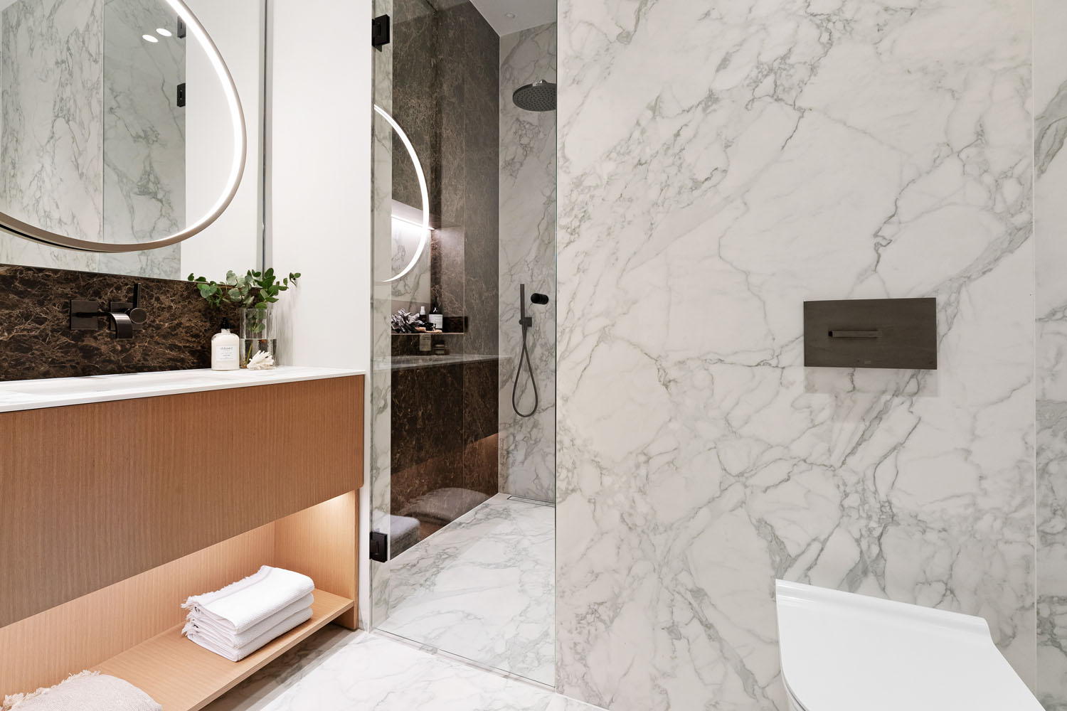 Badet er preget av naturlige elementer som treverk og marmor.