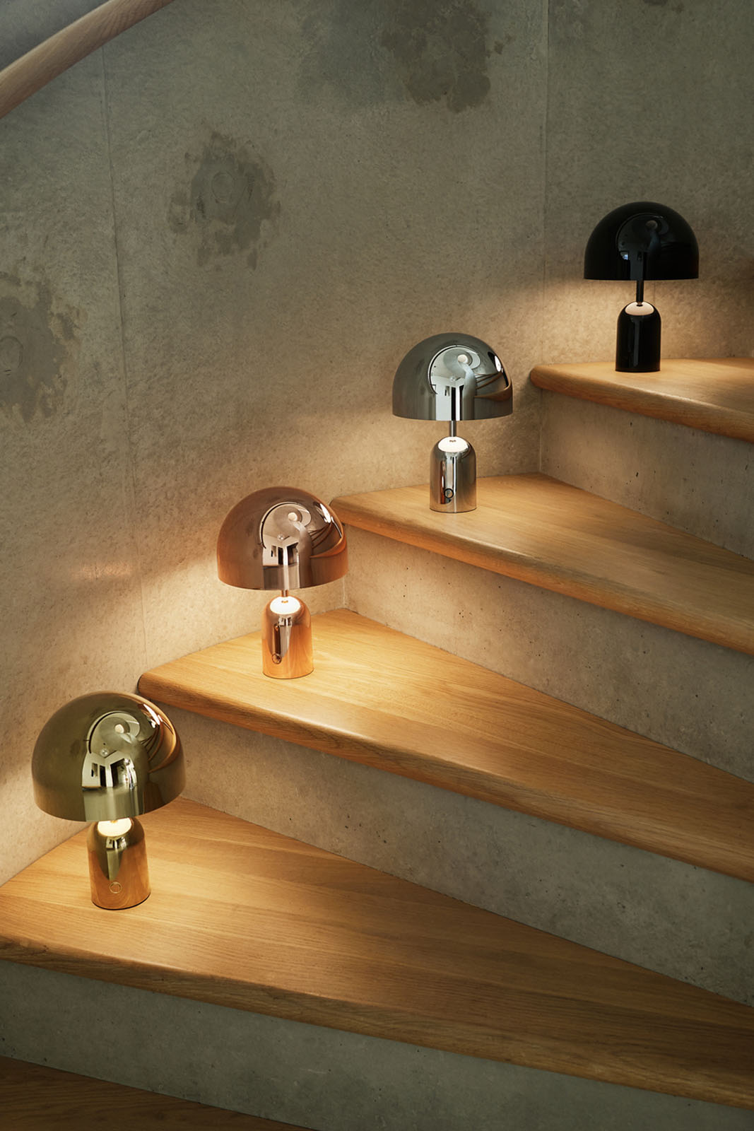 Bell-lamper i gull, kobber, sølv og svart finish, utstilt på trapp.